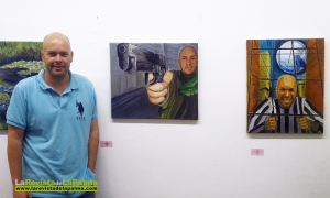 Uno de los alumnos del curso de pintura junto a dos autoretratos